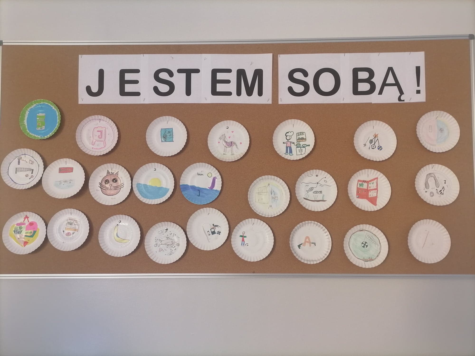 Zdjęcie przedstawia loga zaprojektowane przez uczniów klasy IVc. Ponad pracami uczniów widnieje hasło: "jestem sobą".