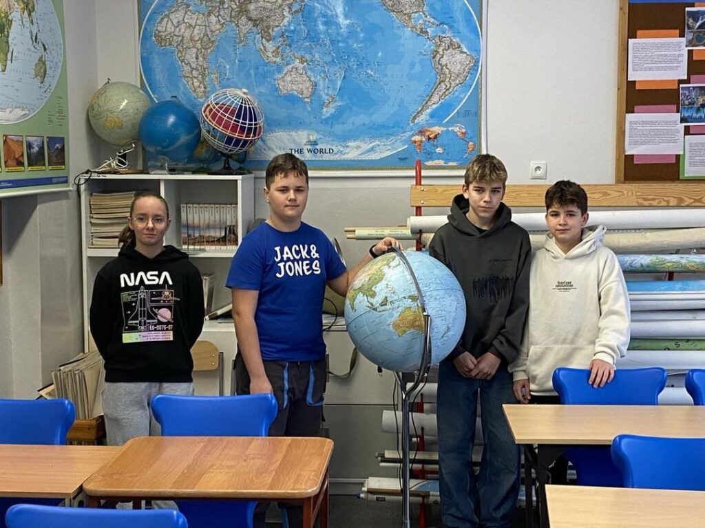 Zdjęcie przedstawia czwórkę uczniów, którzy do etapu rejonowego konkursu z geografii.